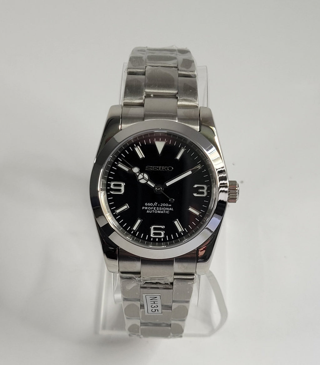 Silver Seiko watch with black face on a white background