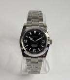 Silver Seiko watch with black face on a white background