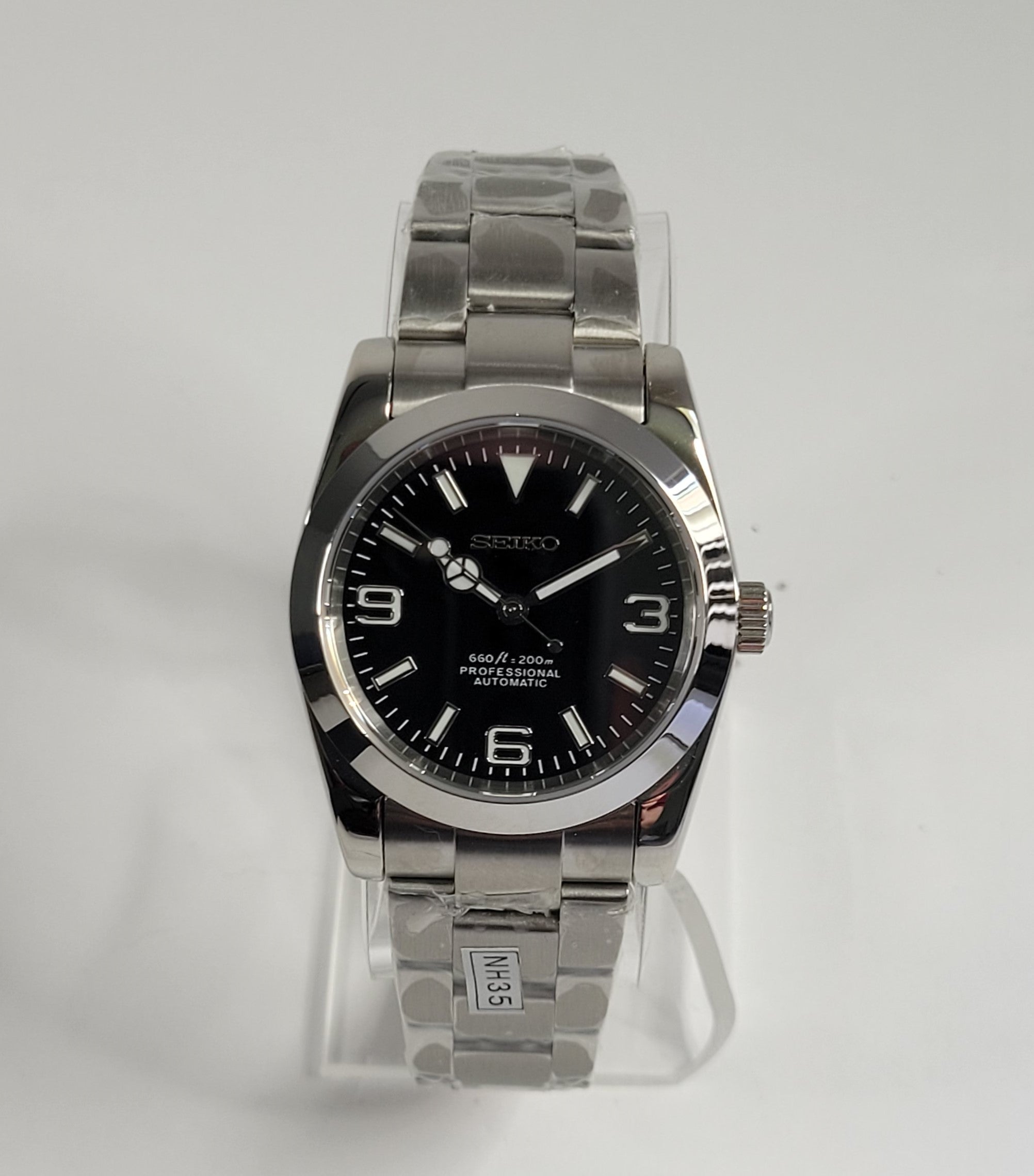 Silver Seiko watch with black face on a white background