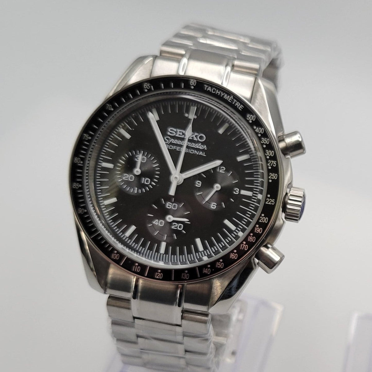 Silver Seiko watch with black dial on a white background