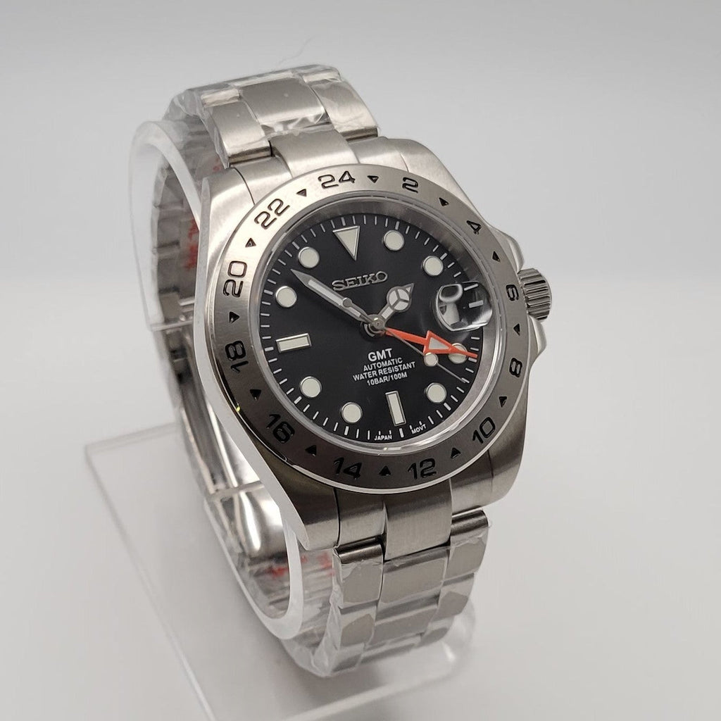 Silver watch with a black dial on a white background