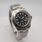Silver watch with a black dial on a white background