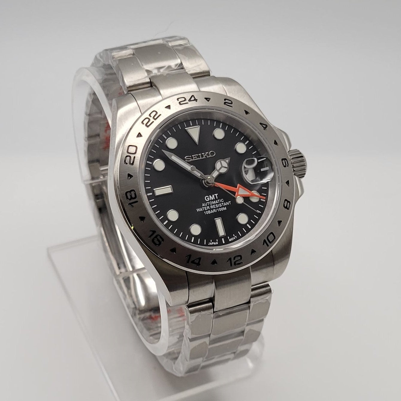 Silver watch with a black dial on a white background