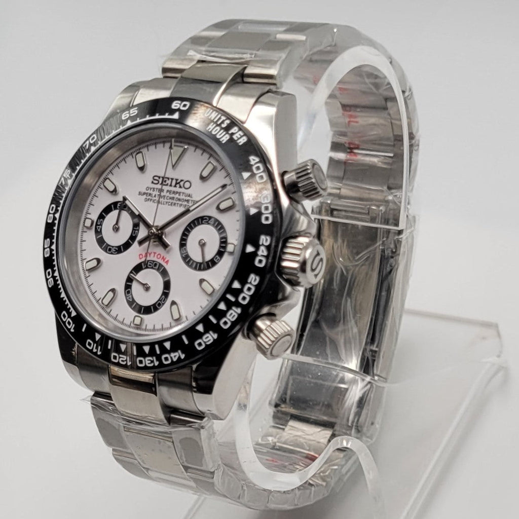 Silver Seiko watch on a clear stand against a white background