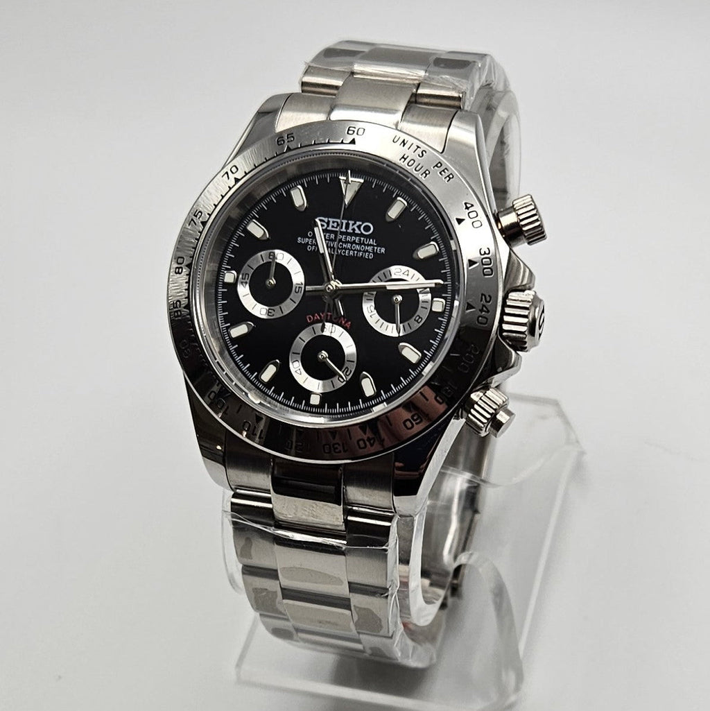 Seiko watch with black face and silver case on a white background