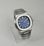 A custom Seiko Nautilus watch with a blue dial, stainless steel integrated bracelet, and a transparent case back displayed on a stand.