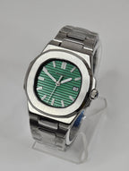 Silver watch with a green face on a gray background