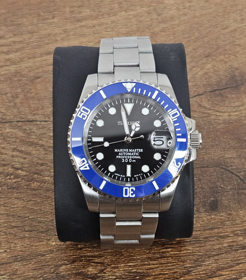 Wristwatch with blue bezel and silver band on wooden surface