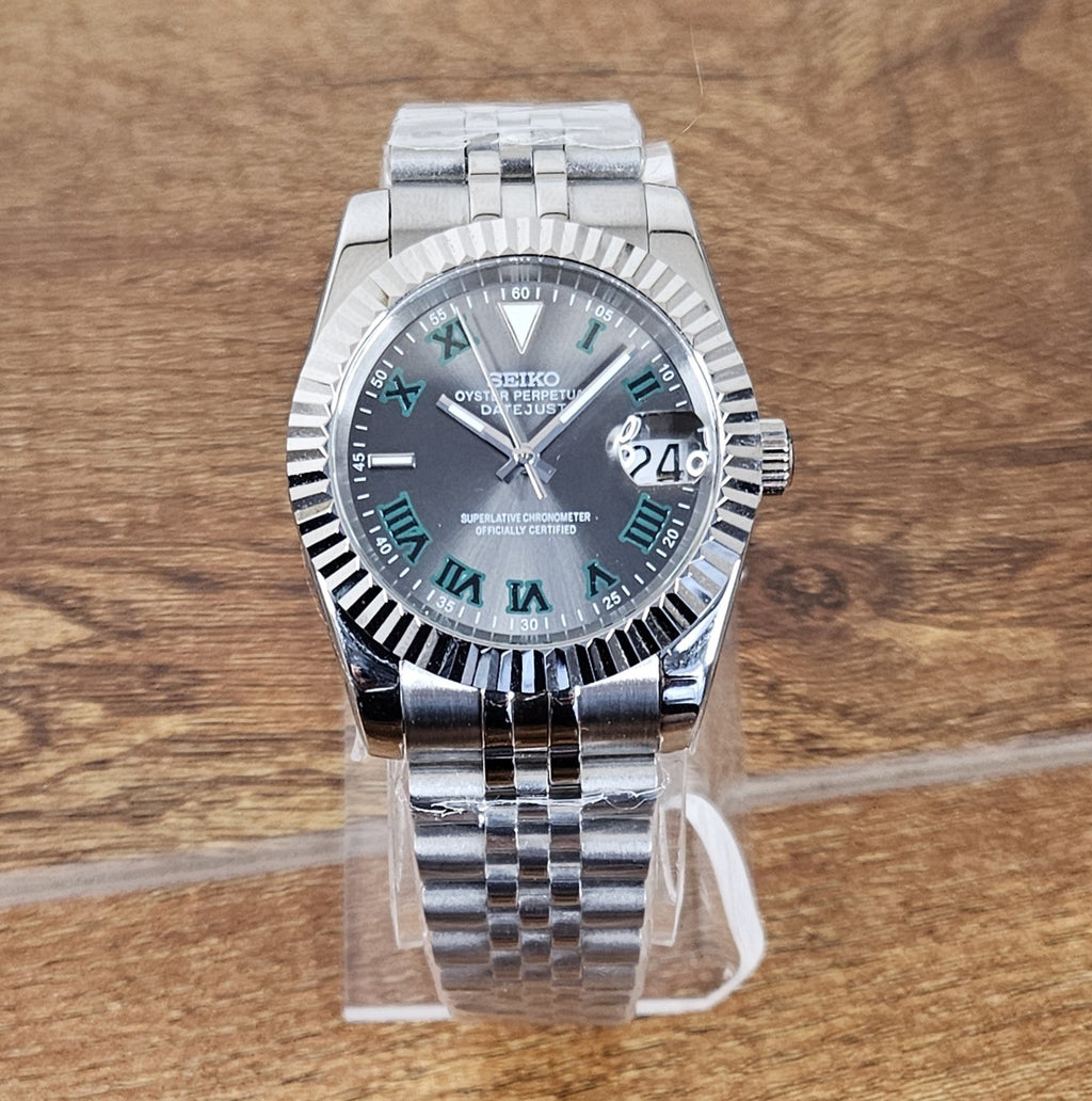 Silver Seiko watch with a dark face on a wooden surface