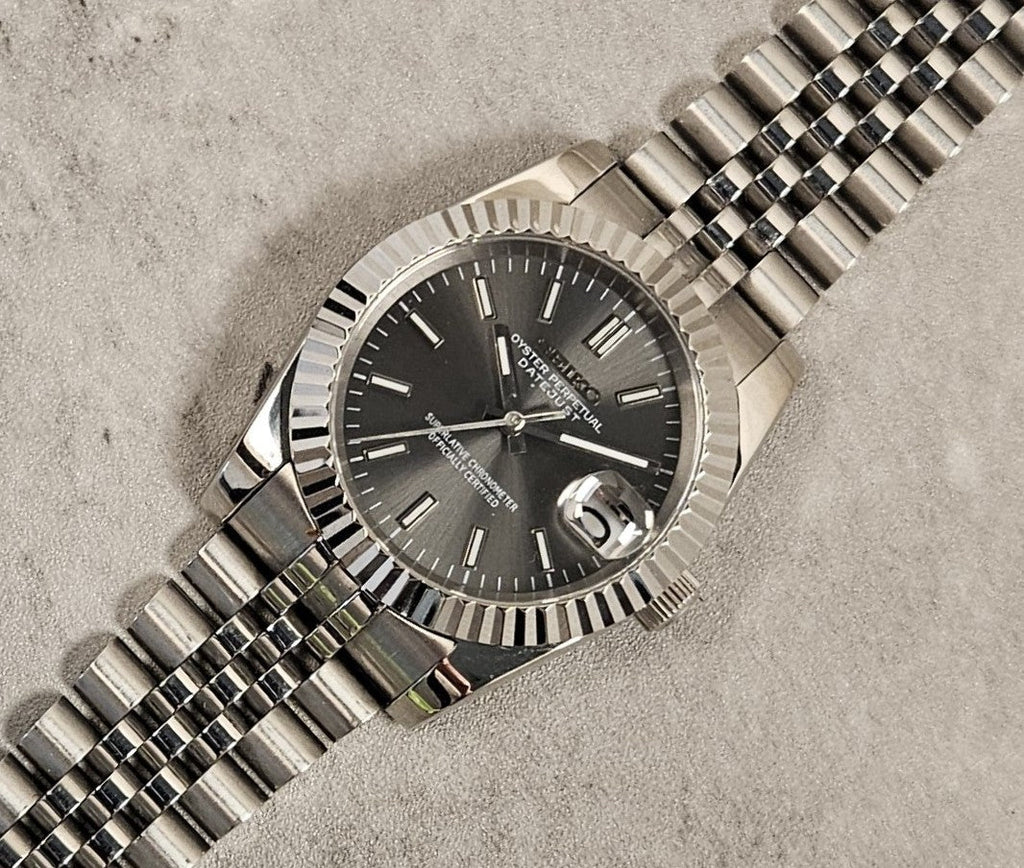 Silver watch with a dark face on a textured surface