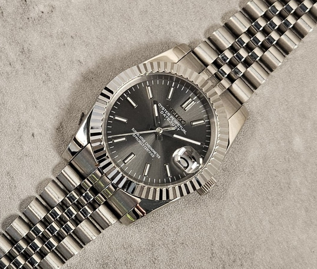 Silver watch with a dark face on a textured surface