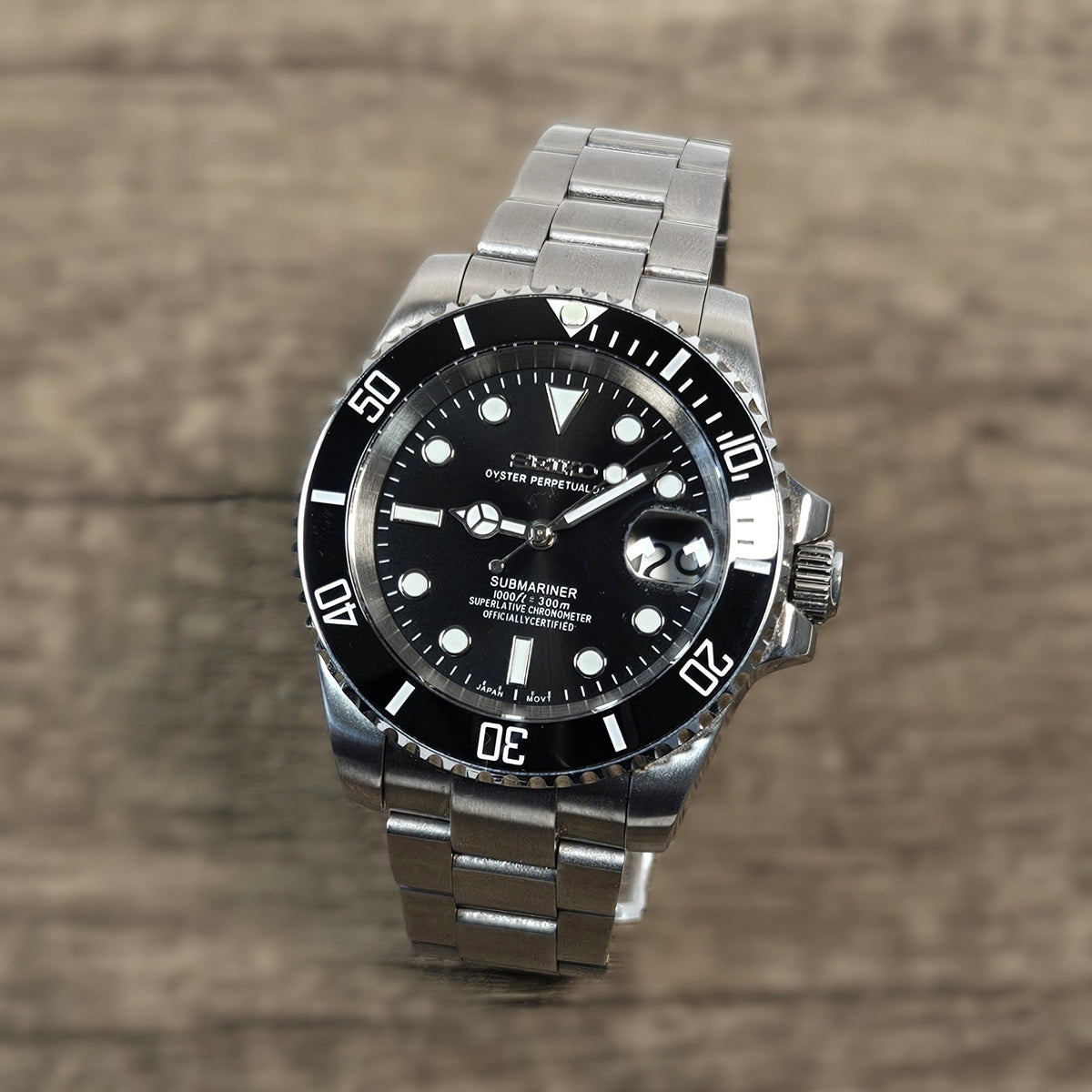 Silver watch with black dial on a wooden surface