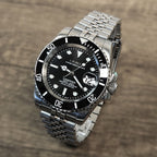Silver wristwatch with black dial on a wooden surface