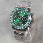A Seiko stainless steel chronograph watch with a green dial and green bezel, displayed on a clear stand against a light gray textured background.