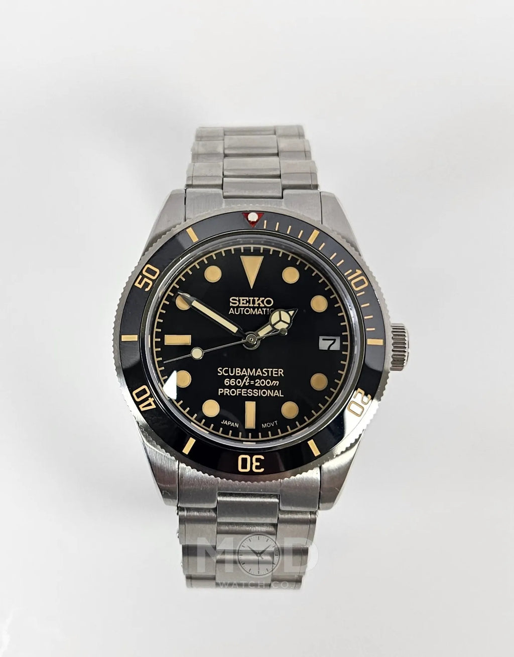 Seiko watch with black dial and silver metal strap on a white background