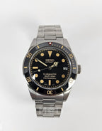 Seiko watch with black dial and silver metal strap on a white background