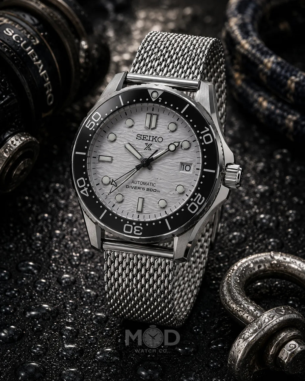 Seiko watch with a silver mesh strap on a dark textured background