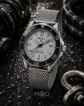 Seiko watch with a silver mesh strap on a dark textured background