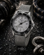 Seiko watch with a silver mesh strap on a dark textured background