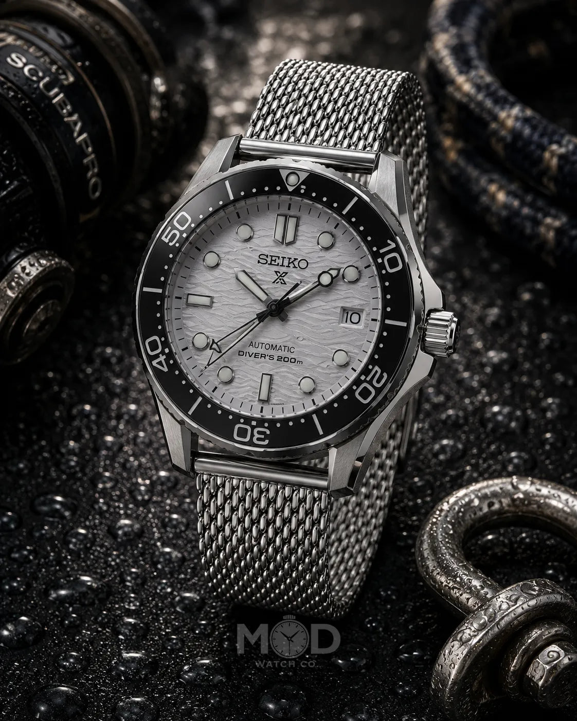 Seiko watch with a silver mesh strap on a dark textured background