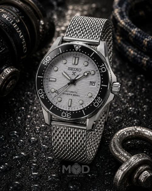 Seiko watch with a silver mesh strap on a dark textured background
