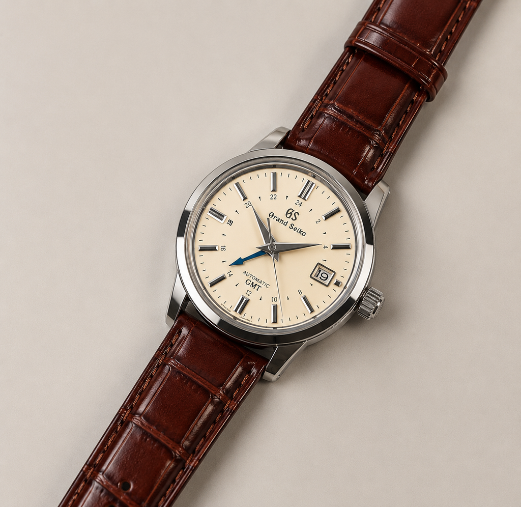 Watch with brown leather strap and cream dial on beige background