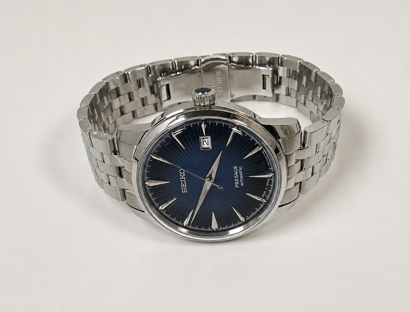 Silver watch with a blue face on a white background