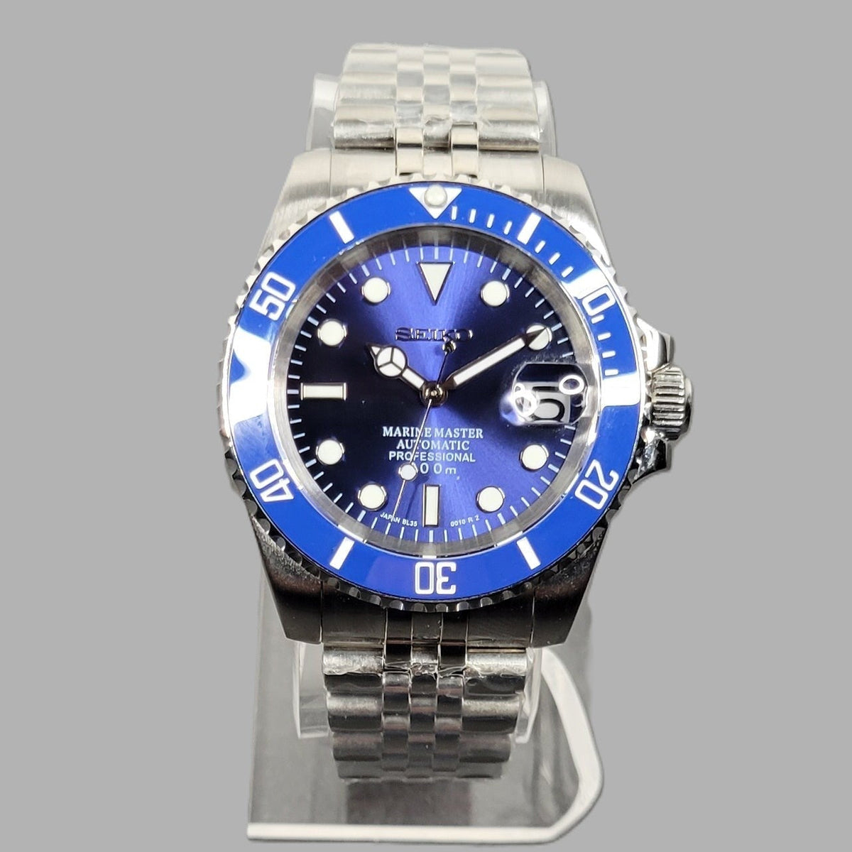 Wristwatch with blue dial and silver metal band on a gray background