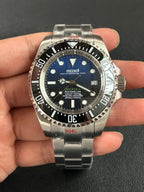 Seiko watch with blue dial held in a hand against a dark background