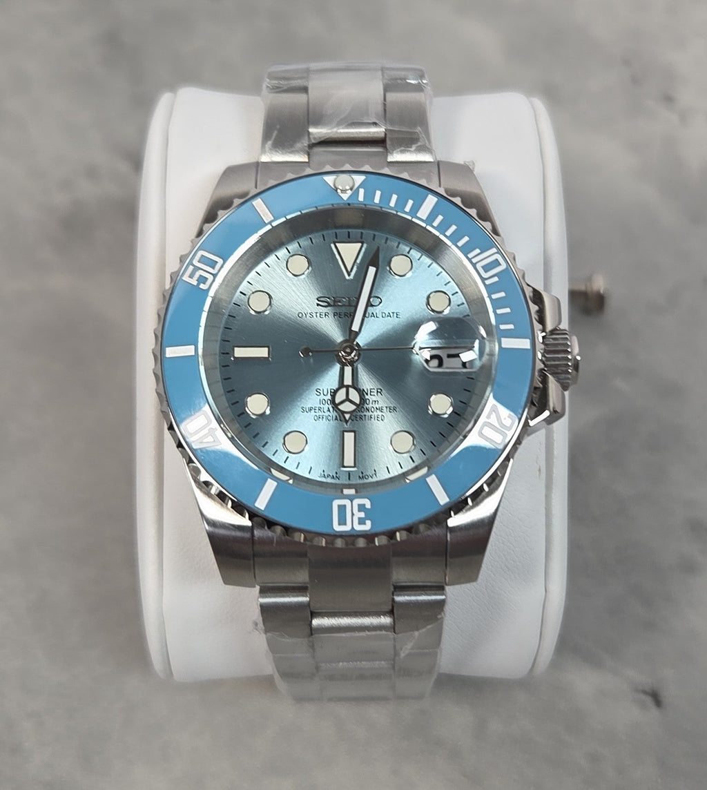 Silver Seiko watch with blue bezel and face on a gray background