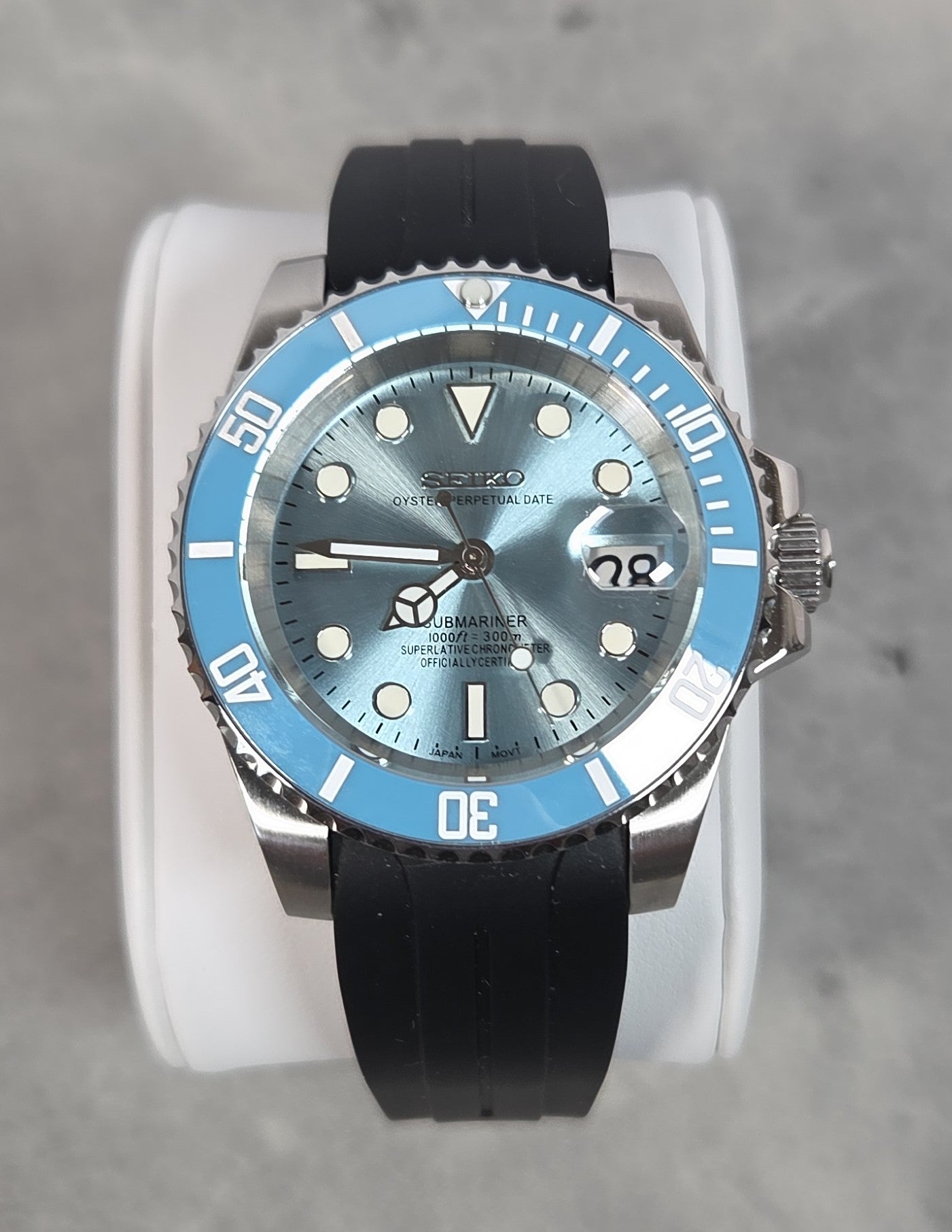 Watch with a blue dial and black strap on a gray background