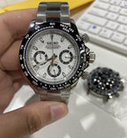 Seiko watch held in a hand with a blurred keyboard in the background